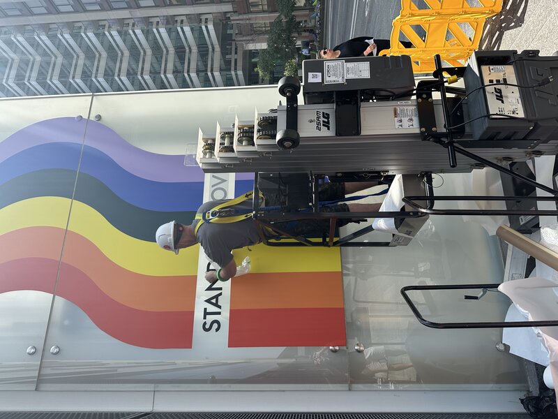 Stand For Love mural — installer on lift